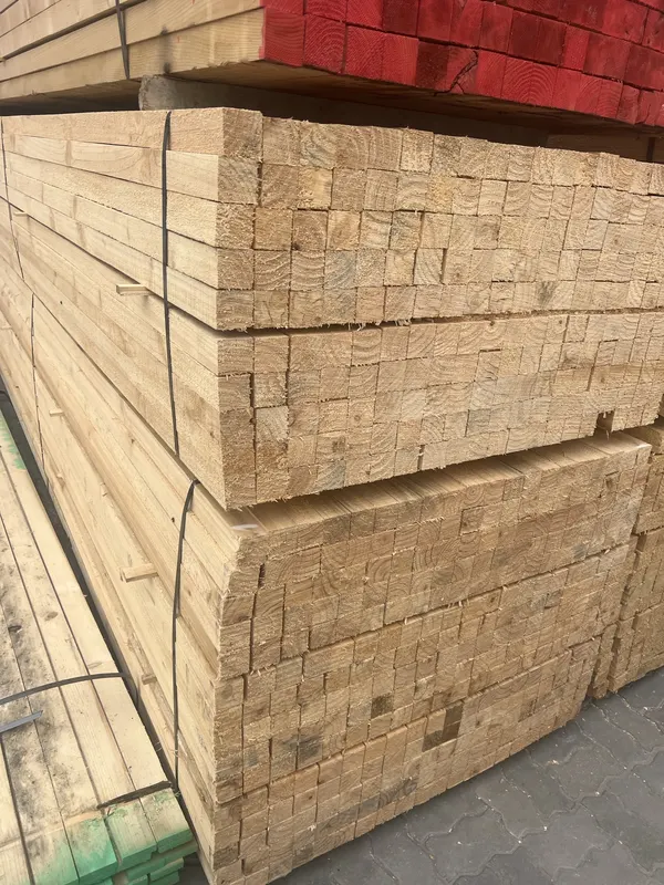 Stacked and strapped bundles of sawn whitewood, with orange-ended bundles above